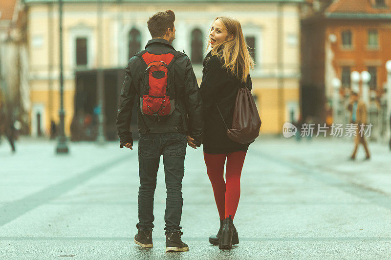 Young couple holding hands, walking in the city